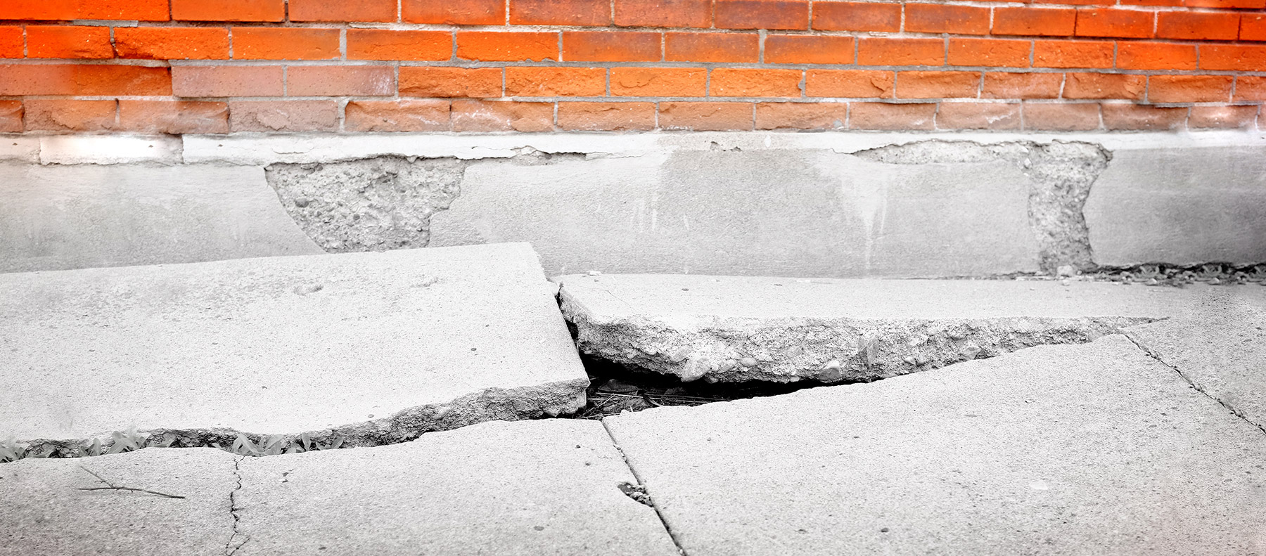 Photo of a destroyed, uneven sidewalk